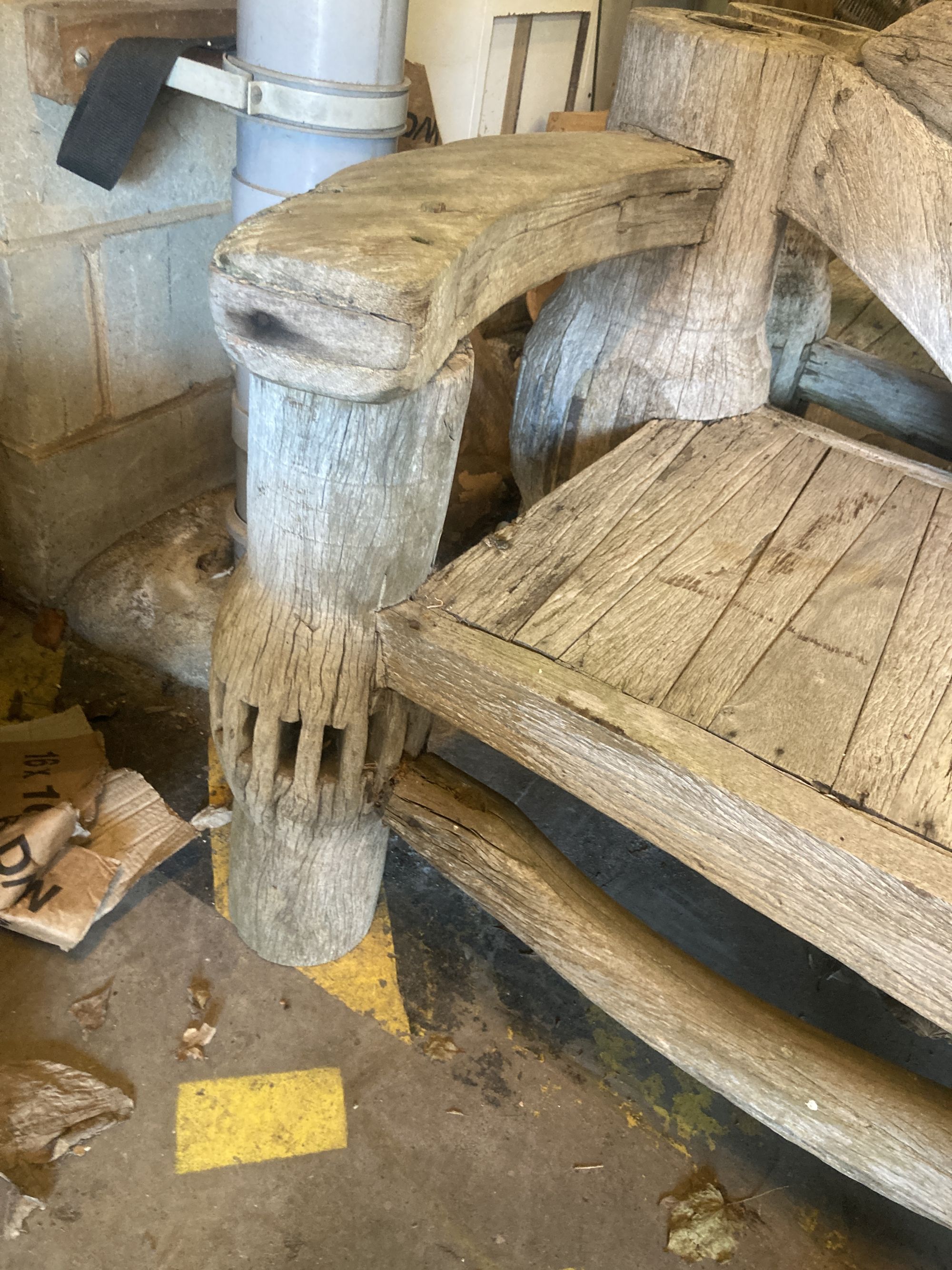 A pair of weathered hardwood cartwheel and hub garden benches, width 184cm depth 75cm height 105cm